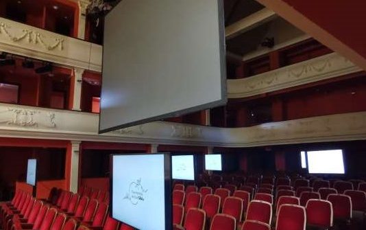 Filarmonia e Sibiut në Rumani, me monitorë në sallë për spektatorët e lidhur në ”zoom”